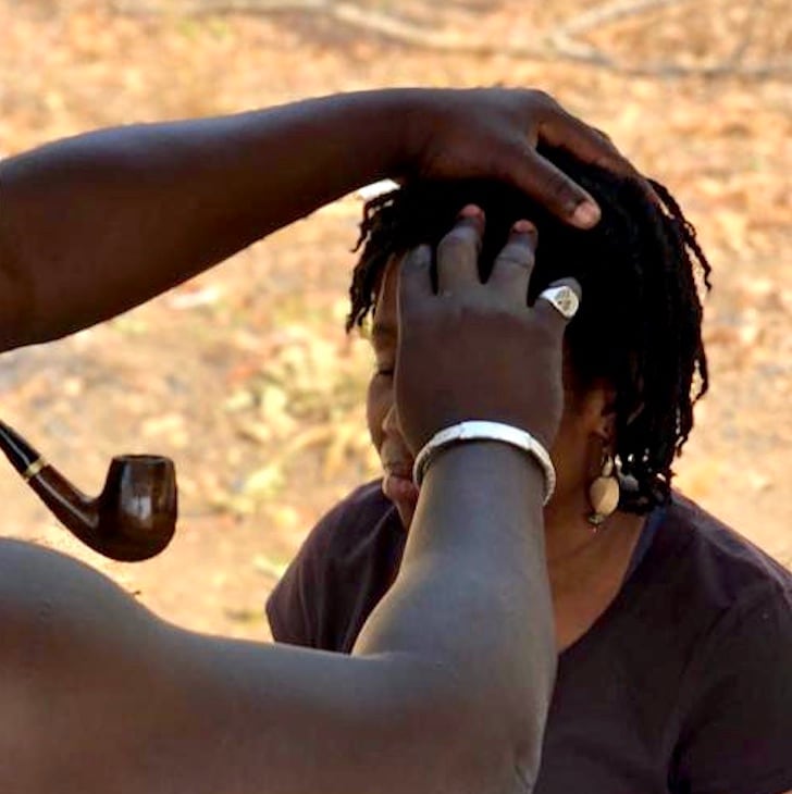 Ankhkasta healer conducting a hands-on head assessment